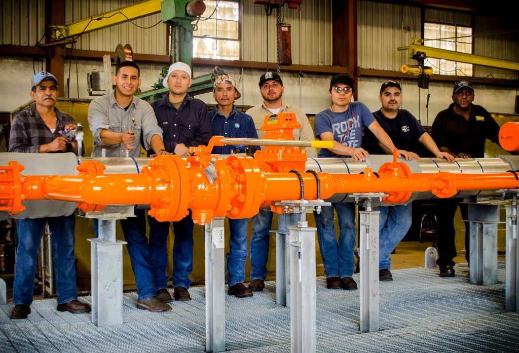 FAB Industries team with an orange skid in the Houston shop